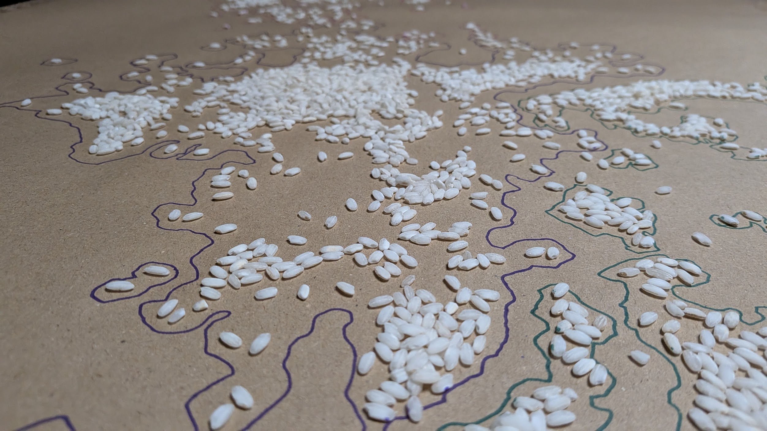 A hand-drawn contour map on kraft paper, marked with scattered grains