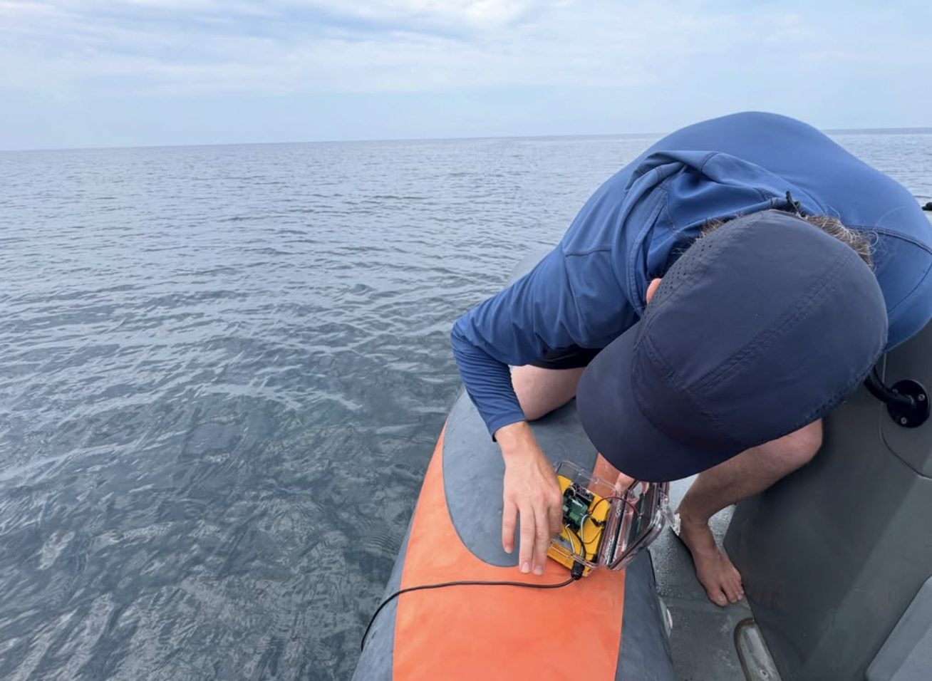 Lowering a sensor over the side of an inflatable into calm water